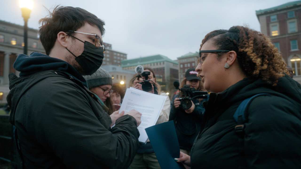 a man with a mask talking to a woman
